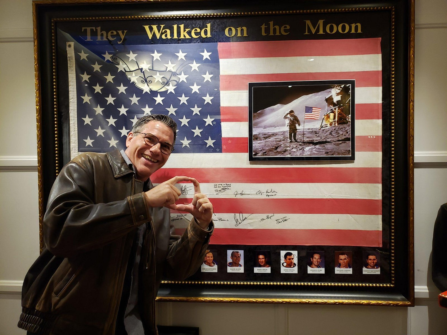 Zach Waldman in front of American flag signed by every man who walked on the moon.