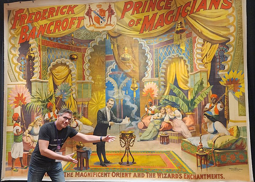 Zach Waldman posing in front of Frederick Bancroft Collectible Poster